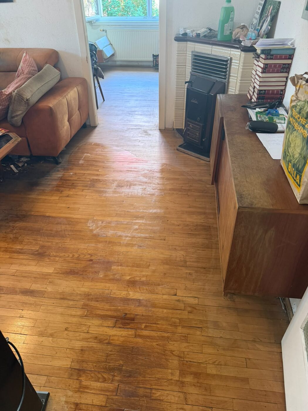 Leergeräumtes Wohnzimmer mit gereinigtem Parkettboden