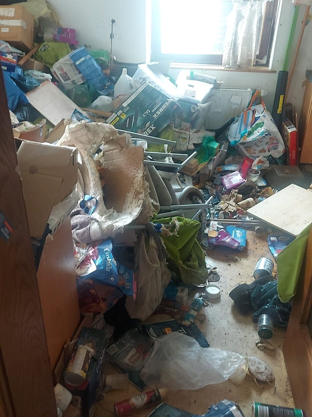 Zimmer mit Müll und Gerümpel bis zum Fenster