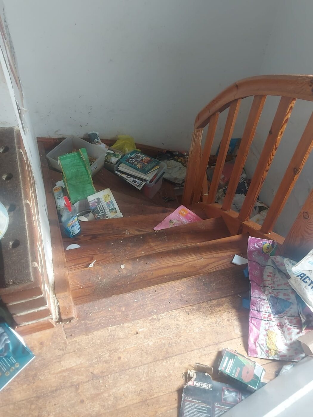 Treppenabsatz mit Zeitschriften und Verpackungsmüll