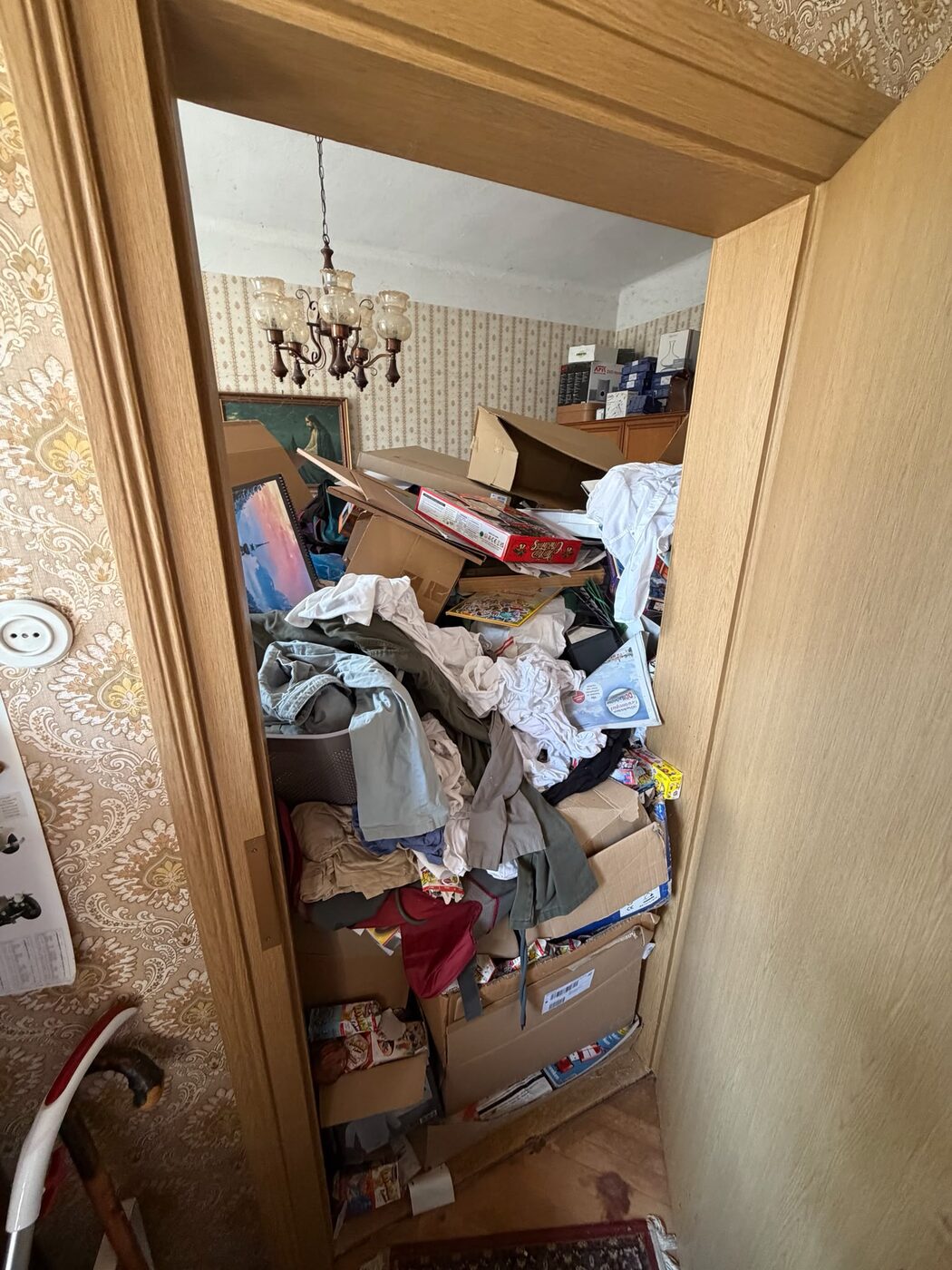 Zugestelltes Zimmer voller Kartons und Wäsche vor der Entrümpelung