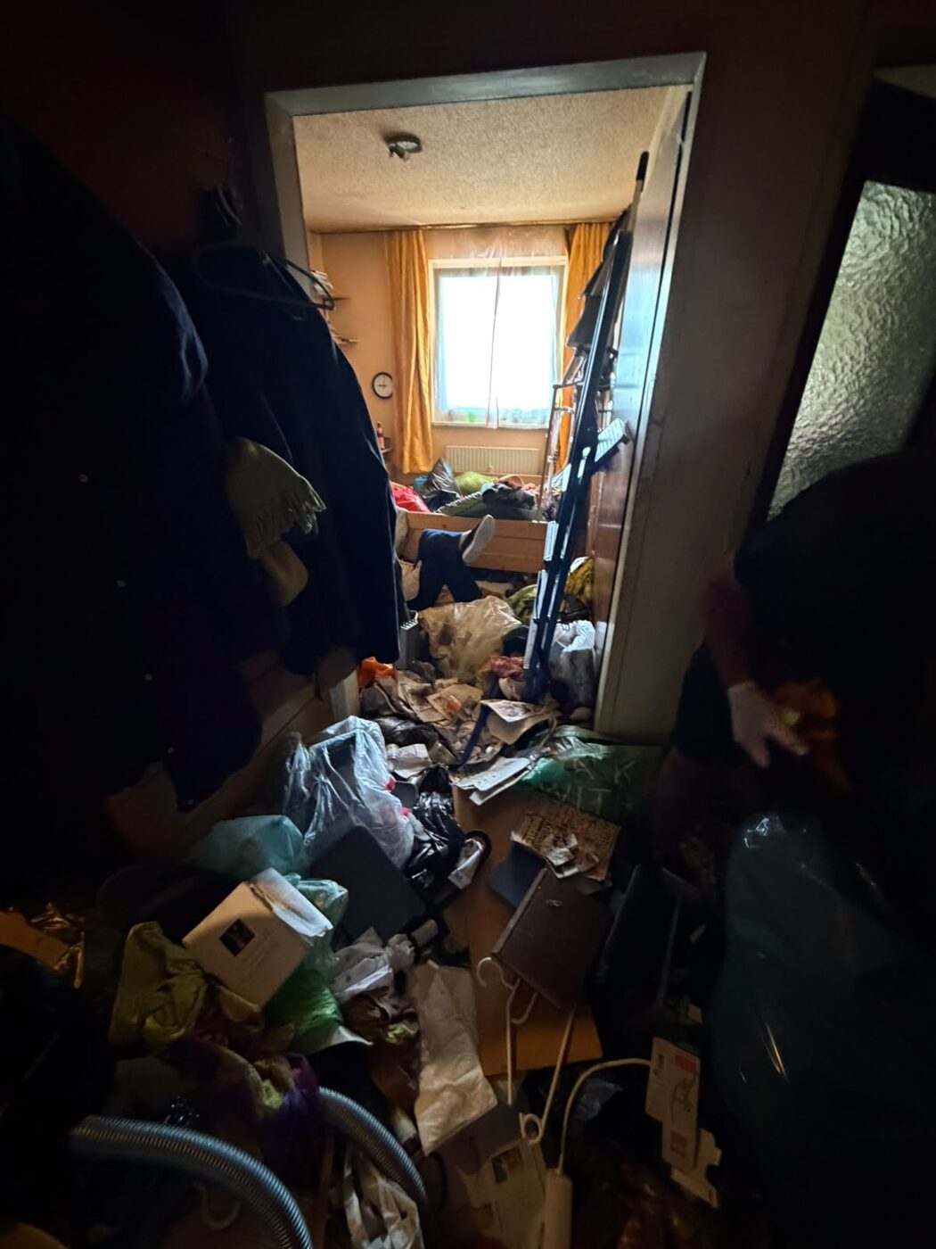 Kaum passierbarer Wohnungsflur vor der Messie-Entrümpelung – Aufräumservice in Oberösterreich